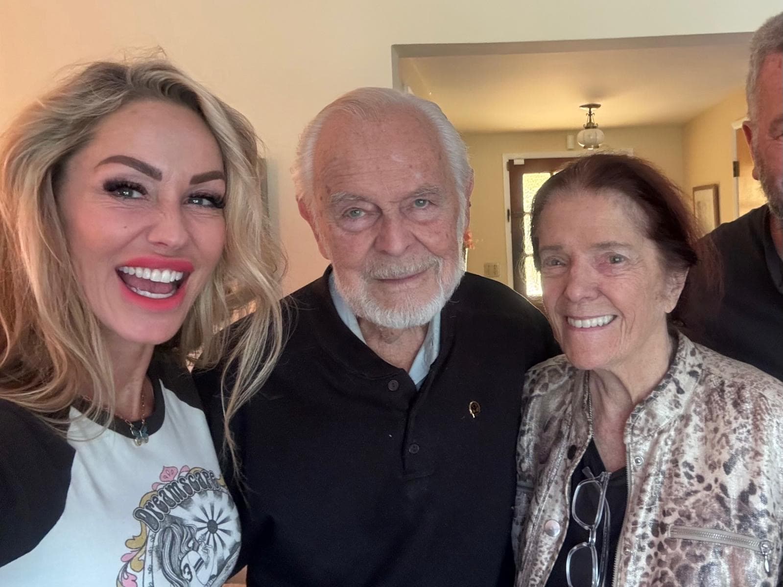 Melanie Marden smiling with an older couple in their home
